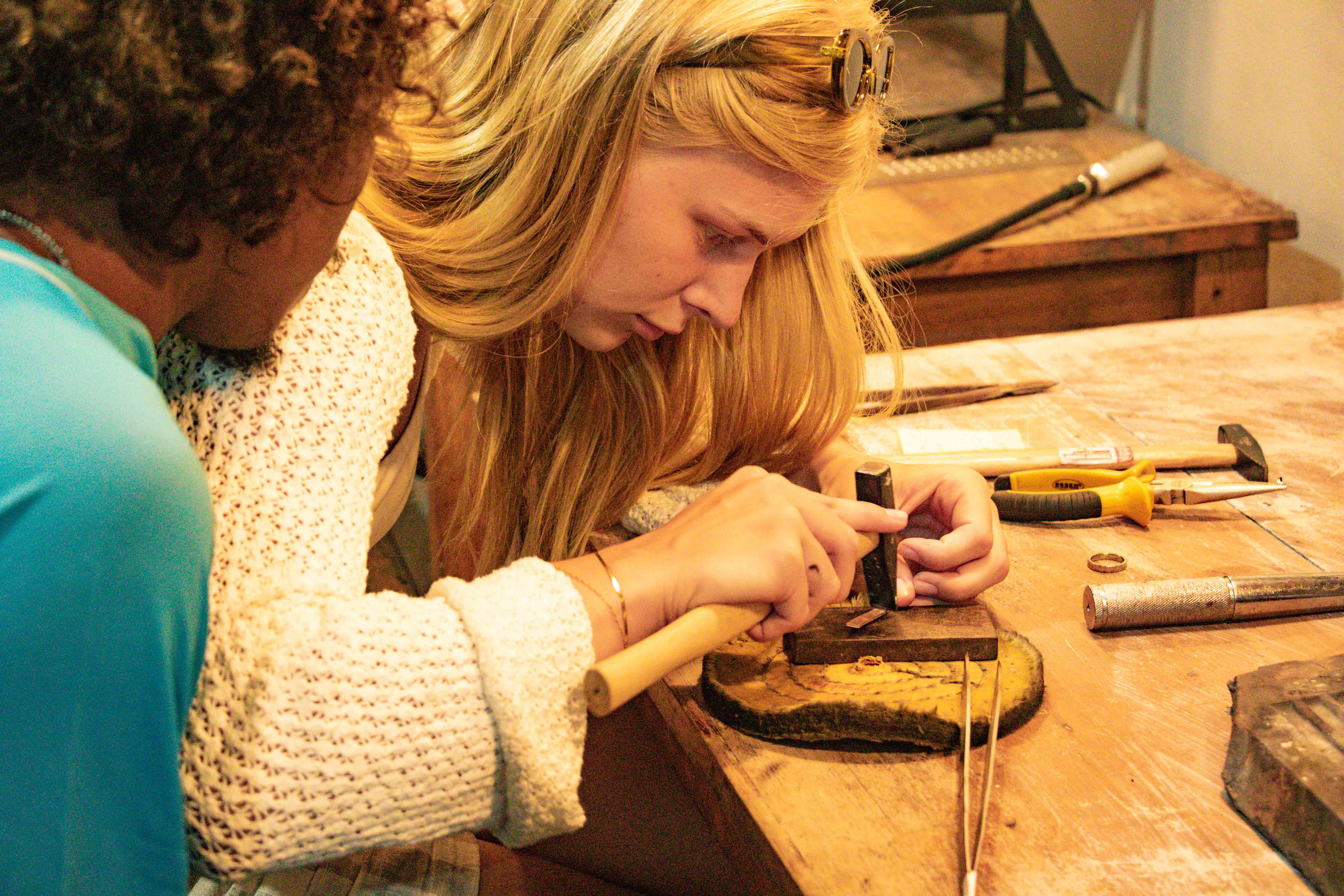 Instructor helping a guest shape a silver piece